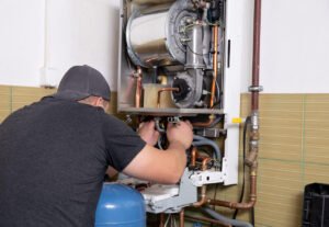 plumber fixing central heating system, Worker servicing a gas bo