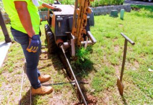 Installing underground communications networks using horizontal directional drilling machines before trenchless laying of a fiber optic cables